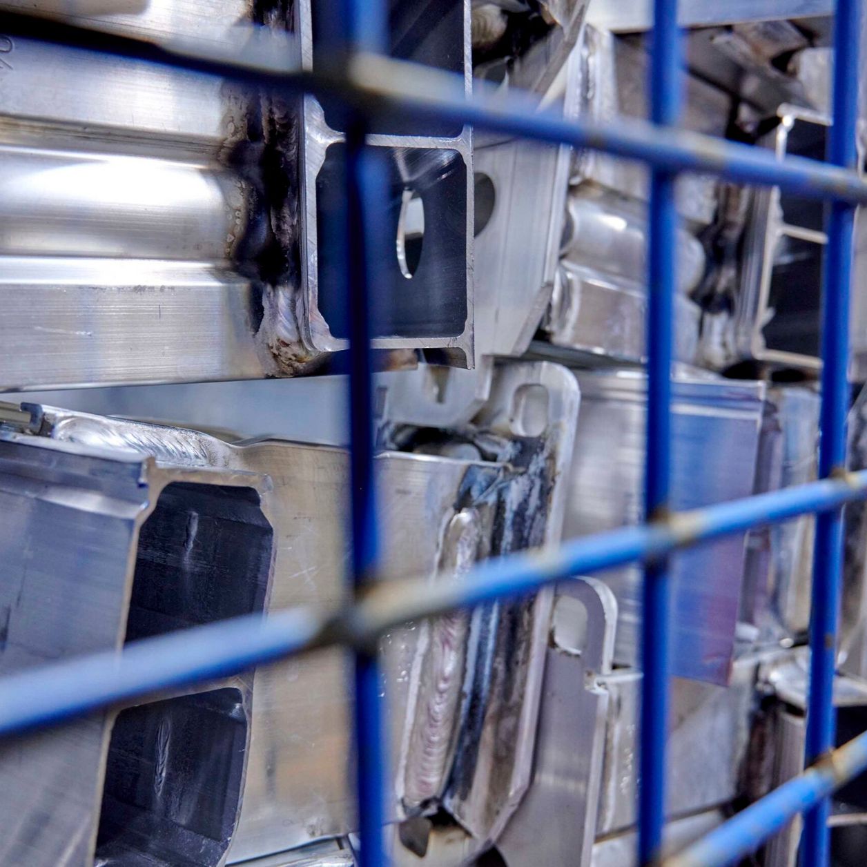 Nahaufnahme Metallteile in blauer Gitterbox