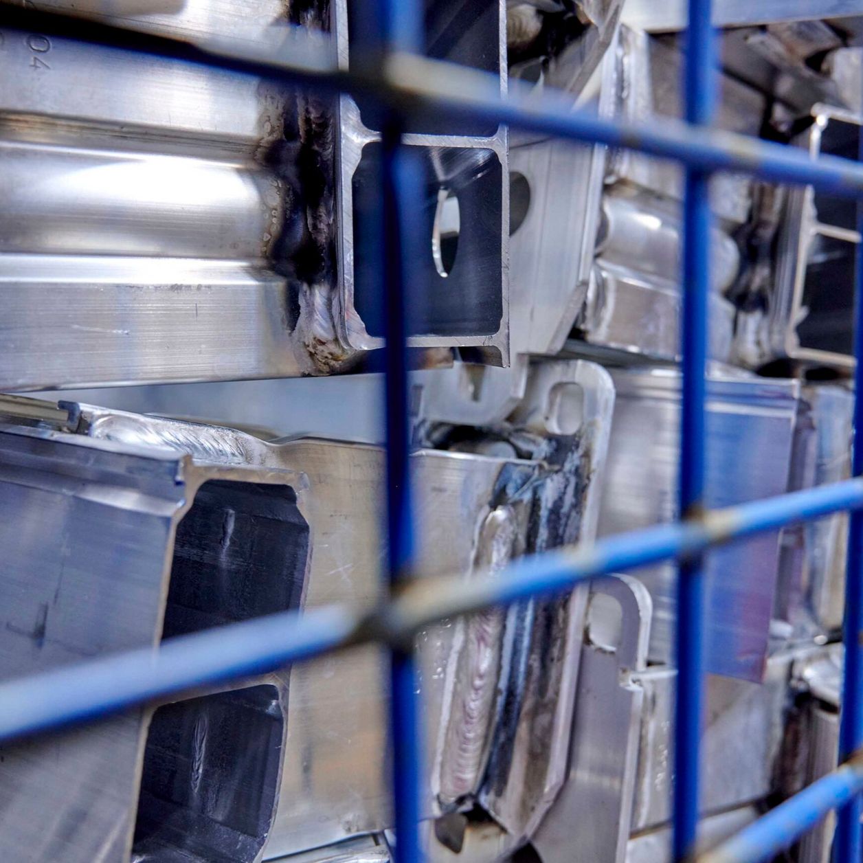 Nahaufnahme Metallteile in blauer Gitterbox