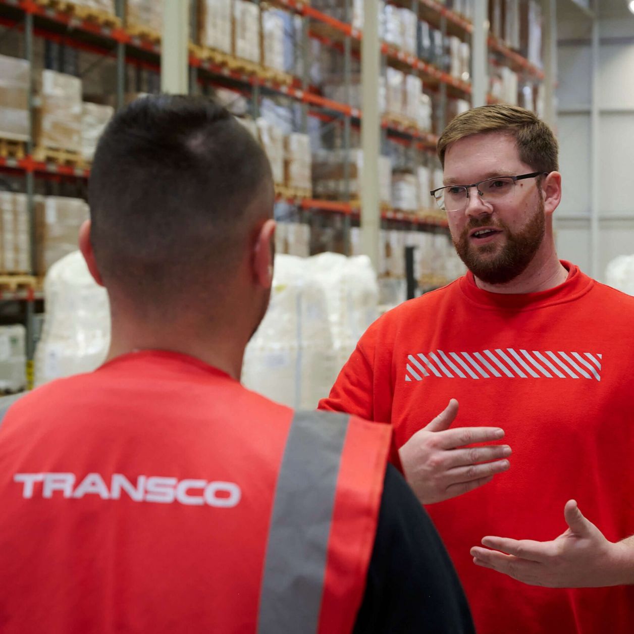 Transco Logistikmitarbeiter im Gespräch in Lagerhalle