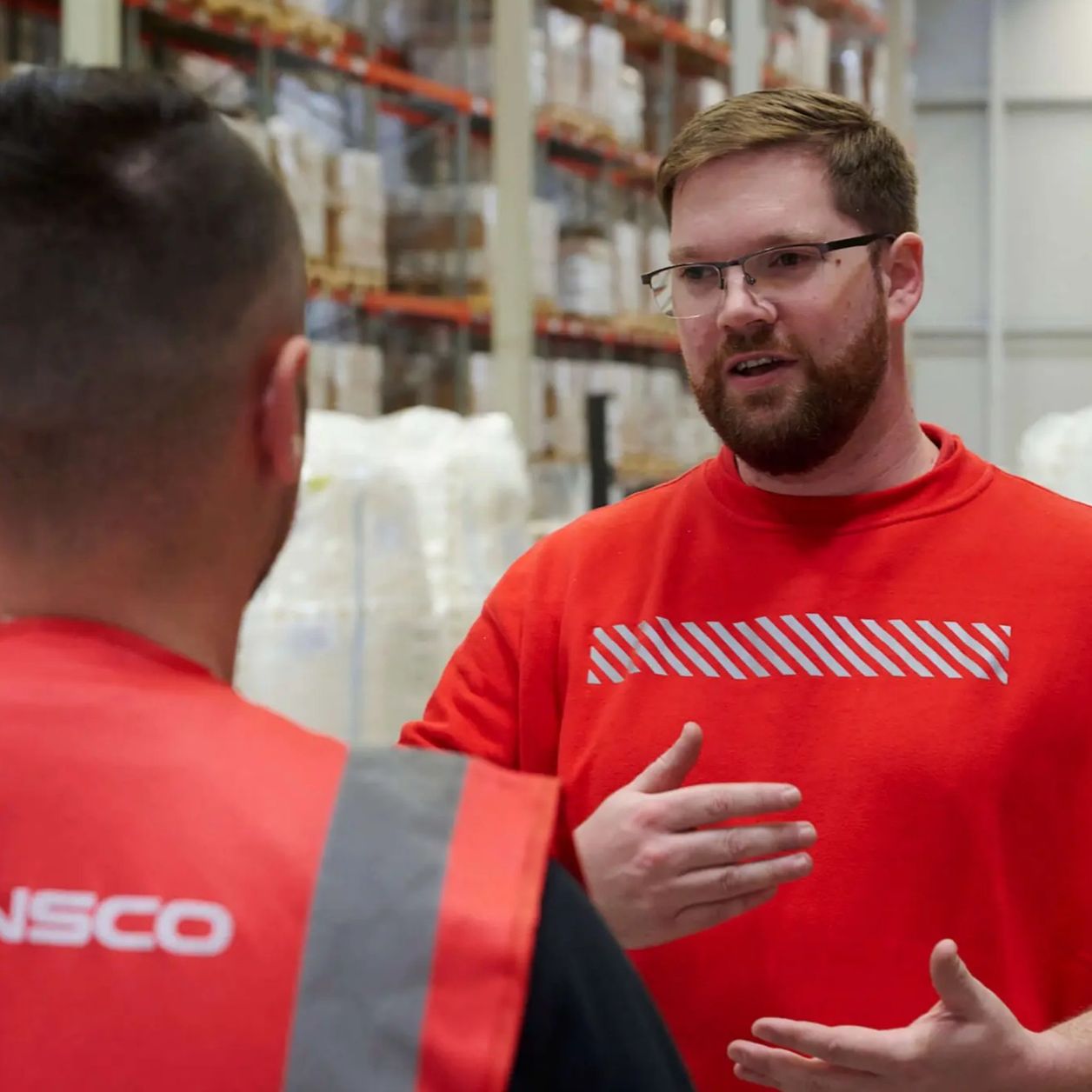 Transco Logistikmitarbeiter im Gespräch in Lagerhalle