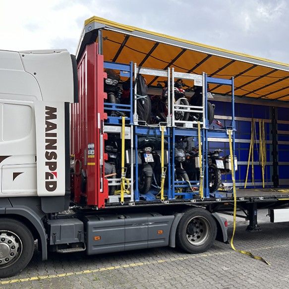 Motorräder in Transportgestellen in einem offenen Lkw der Spedition Transco Mainsped