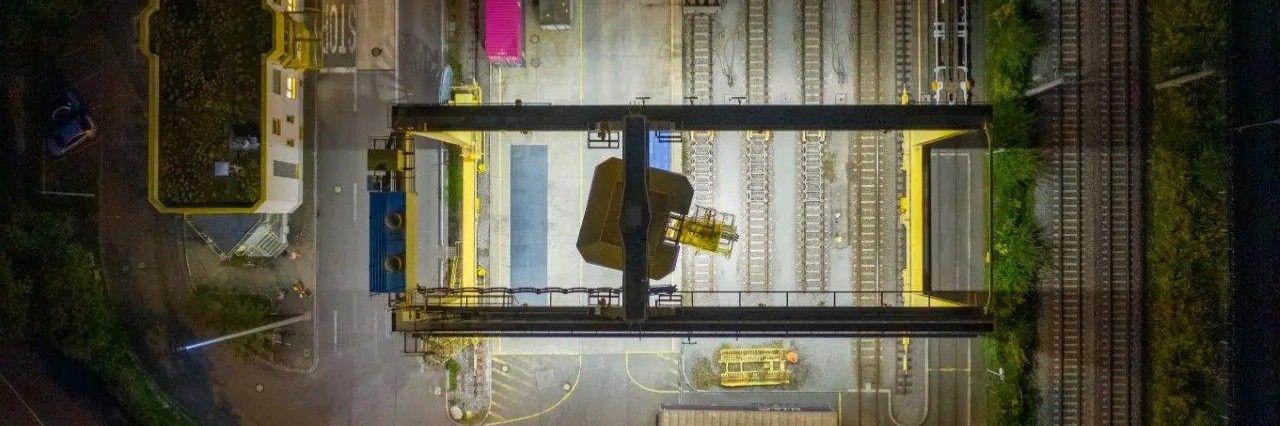 Güterbahnhof mit Kran bei Nacht von oben