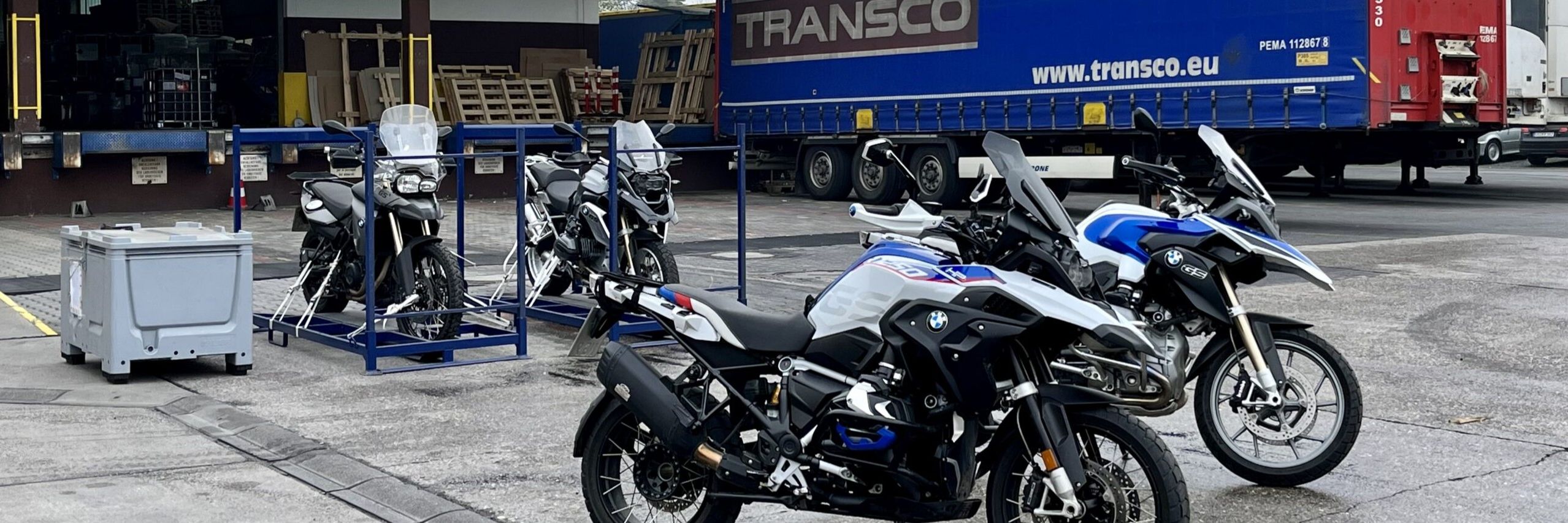 Geparkte Motorräder vor Gebäude der Spedition Mainsped mit Transco Lkw