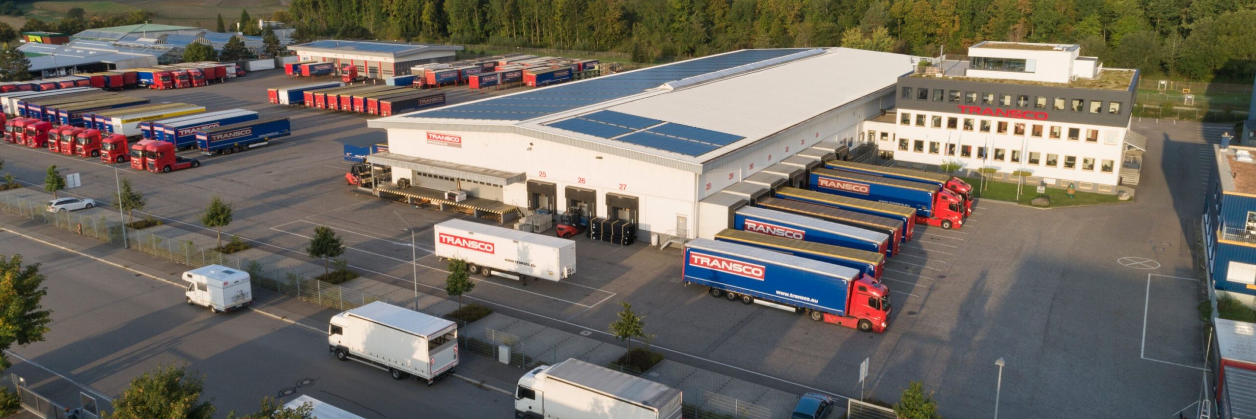 Luftaufnahme des Transco Speditionsstandorts in Singen mit Lagerhallen, LKW und Parkplatz