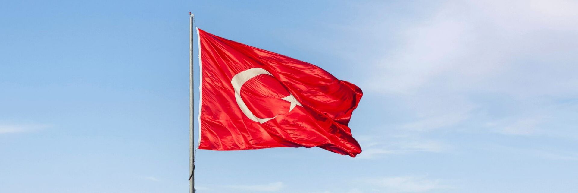 Bandiera turca issata su un pennone, simbolo dei trasporti internazionali tra l'Italia e la Turchia.