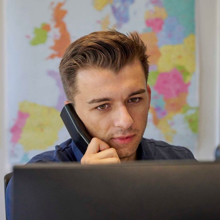 Mitarbeiter Logistikunternehmen Transco telefonierend am PC